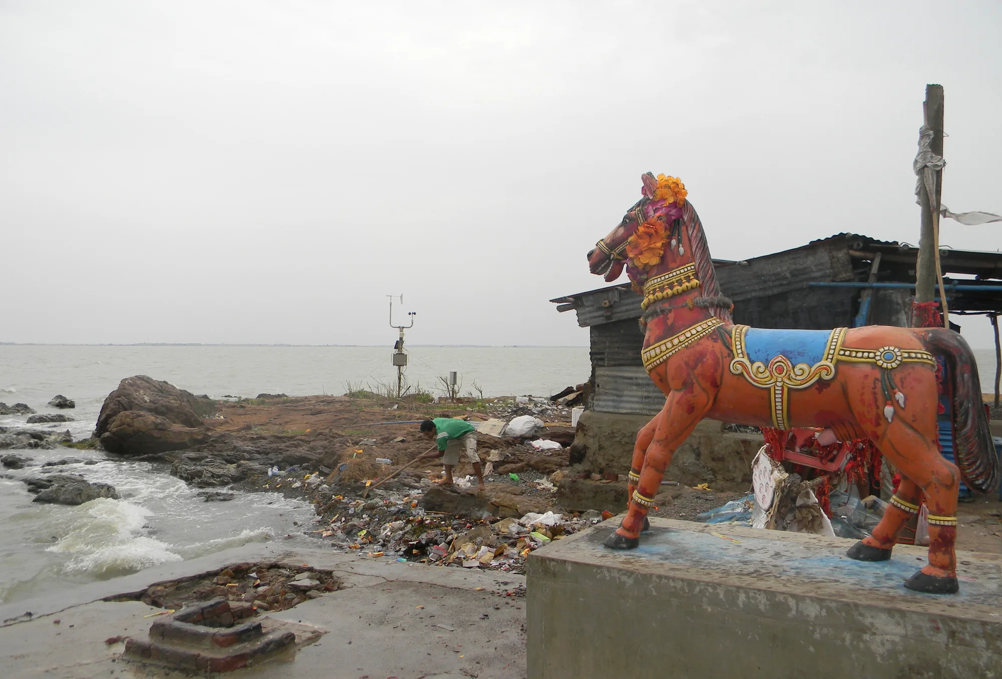 A painted horse statue and shrine on the rocky shore of Kalijai island in Chilika Lake, Odisha
