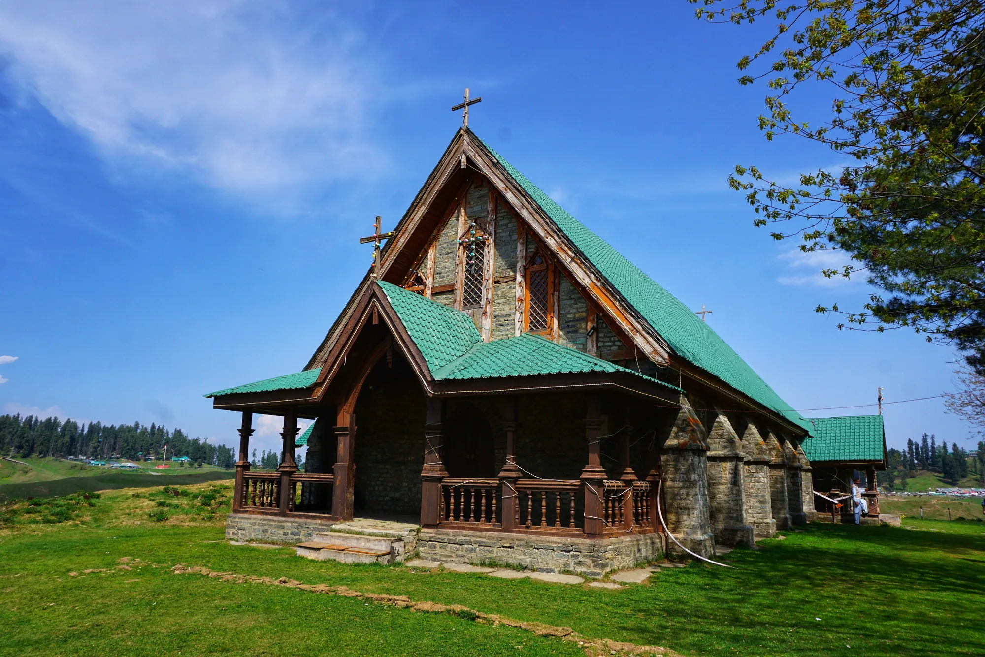 St Mary's Church in Gulmarg, a stone and timber church with a green roof on the meadow under a blue sky