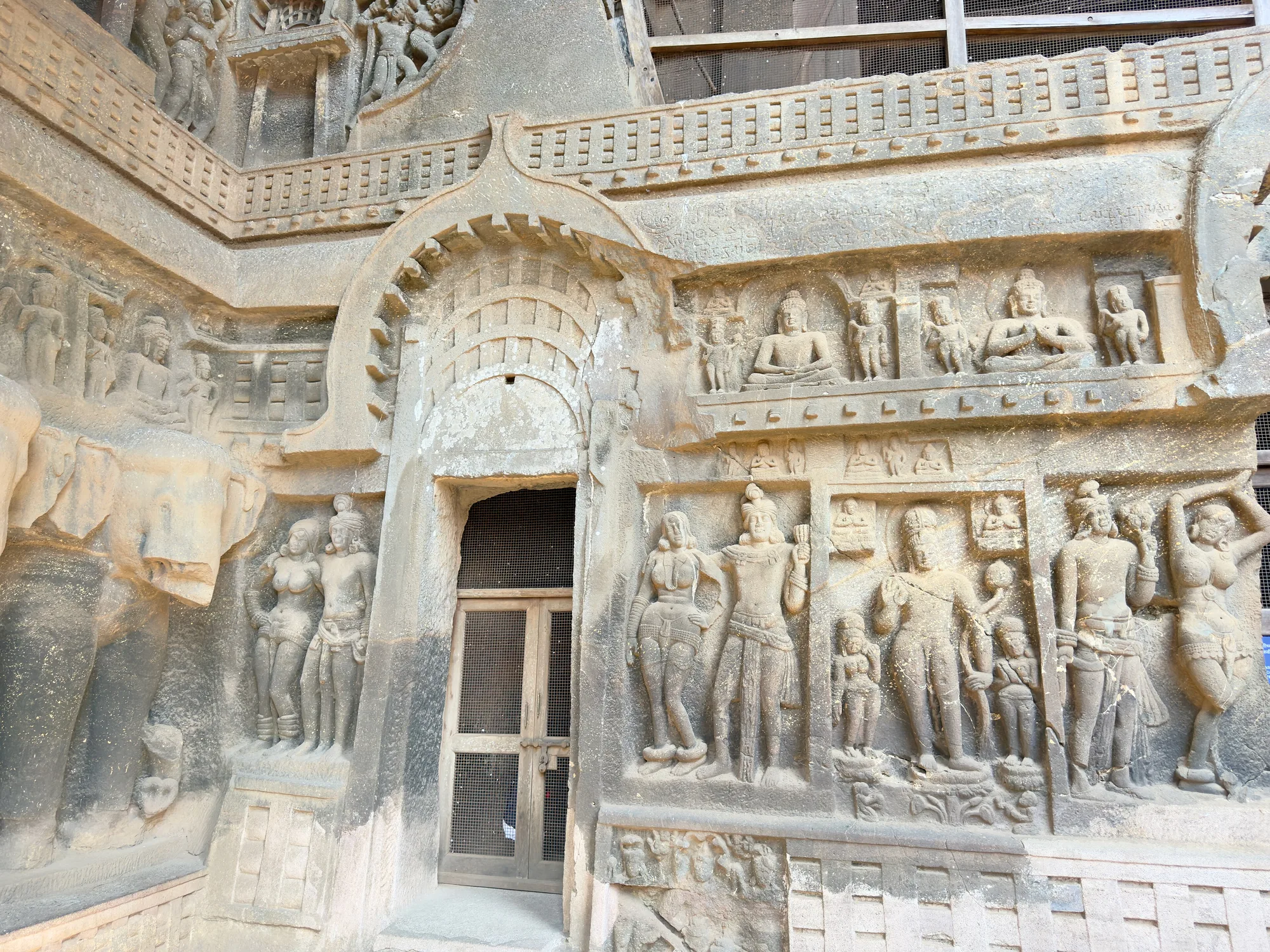 Carved stone figures and a horseshoe arch on the facade of the Grand Chaitya at Karla Caves near Lonavala