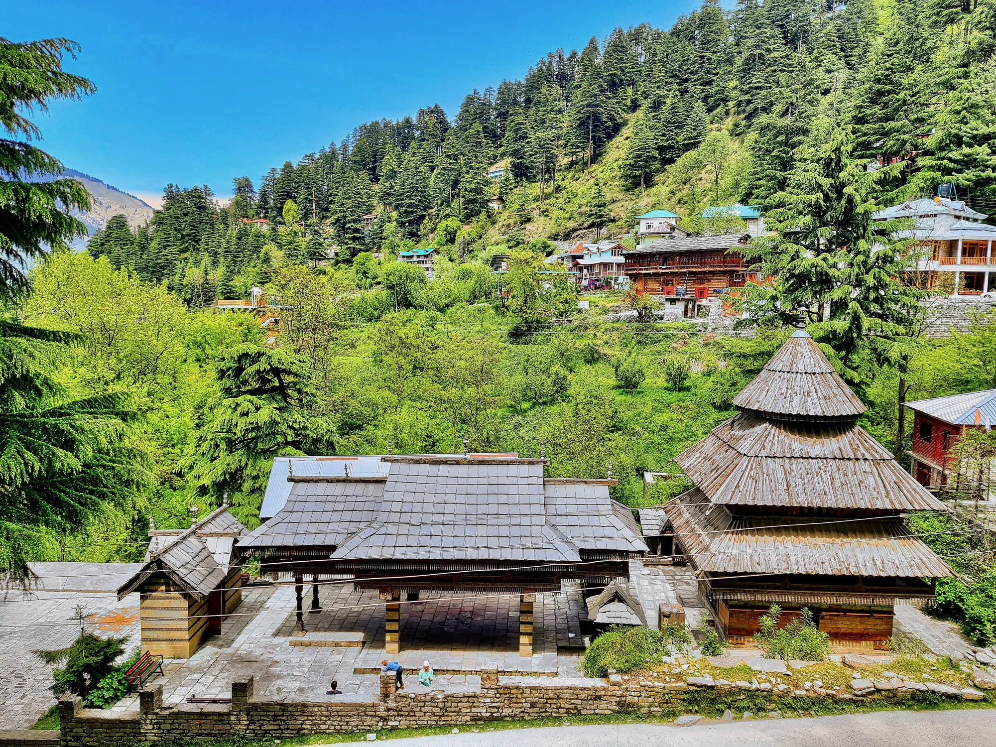 Tripura Sundari temple in Naggar with tiered wooden pagoda roofs in front of forested hills and village houses