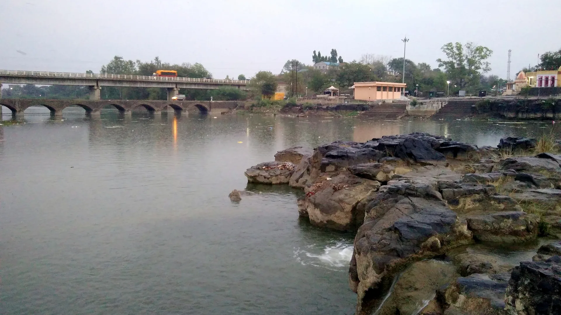 Dham river with rocks and a road bridge beside Paunar Ashram near Wardha, the last stop on a car rental in Nagpur loop