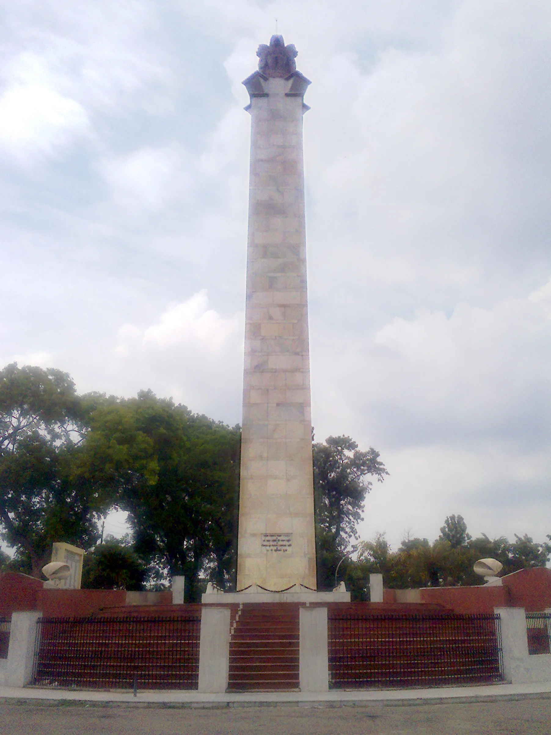 Marble column of Shaheed Smarak martyrs' memorial on Delhi Road, reached easily with car rental in Meerut