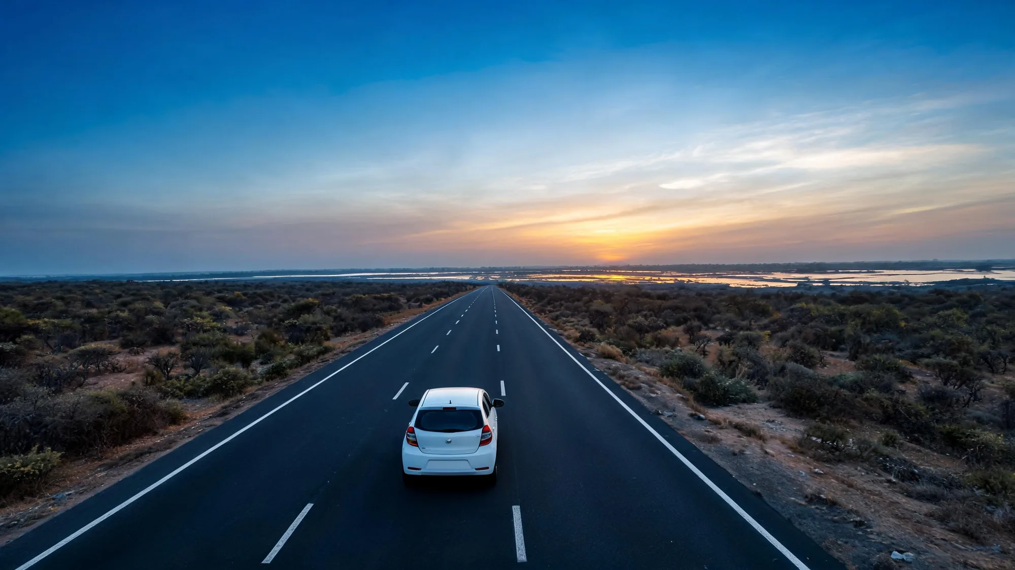 Self-drive car rental in Jaipur: hatchback on a dawn highway toward Bharatpur wetlands