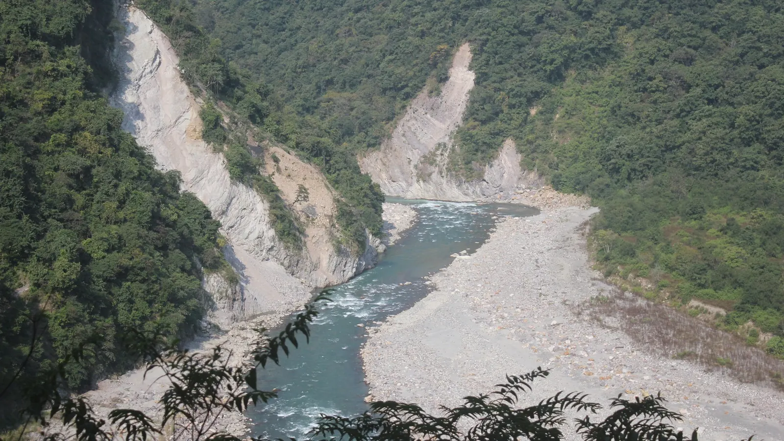 Yamuna river winding through a forested gorge below the Yamunotri road near Mussoorie, the first valley on a bike rental in Mussoorie ride to Barkot