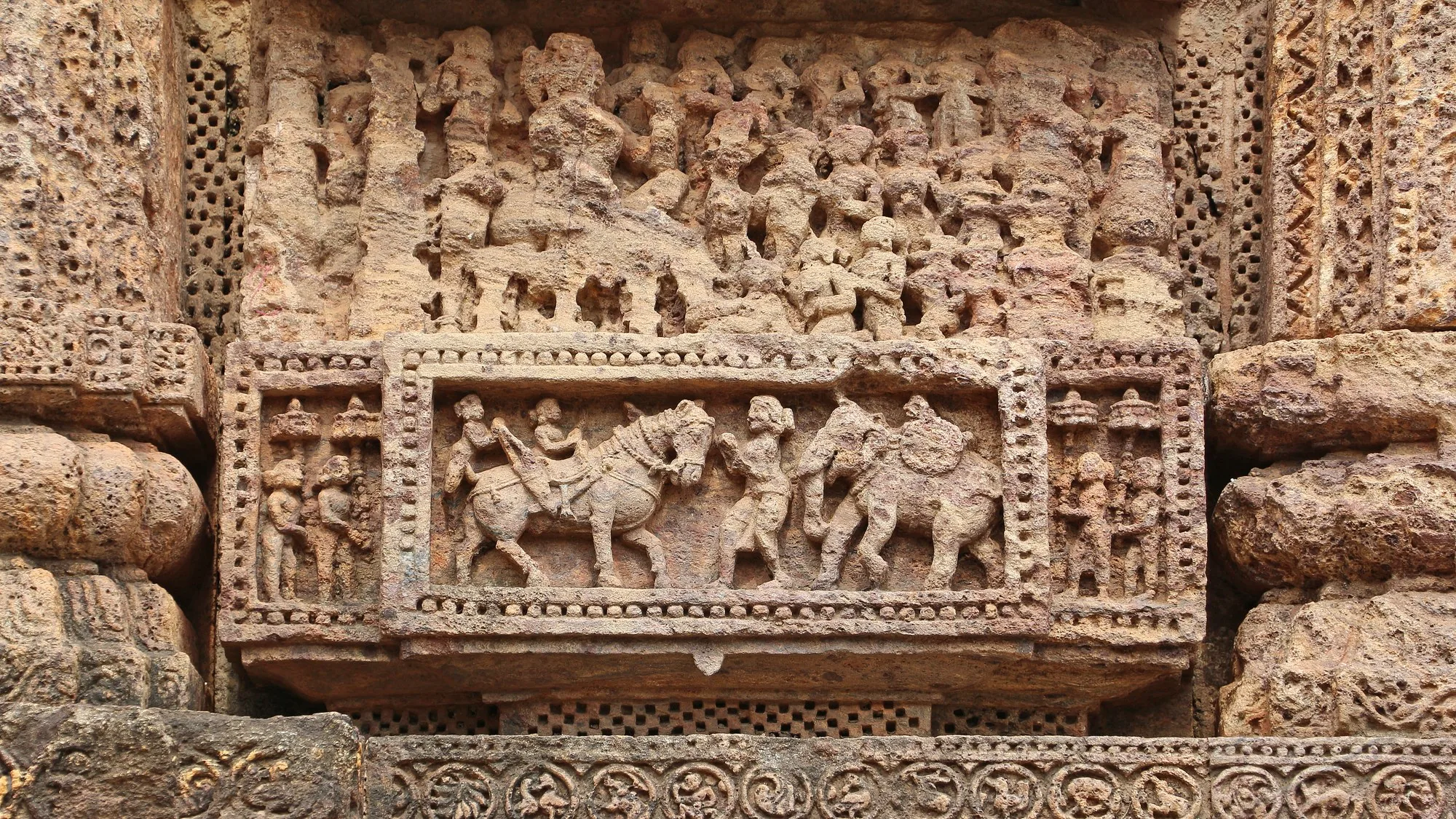 Bas-relief stone carvings on the Konark Sun Temple walls, detail travellers see with car rental in Bhubaneswar