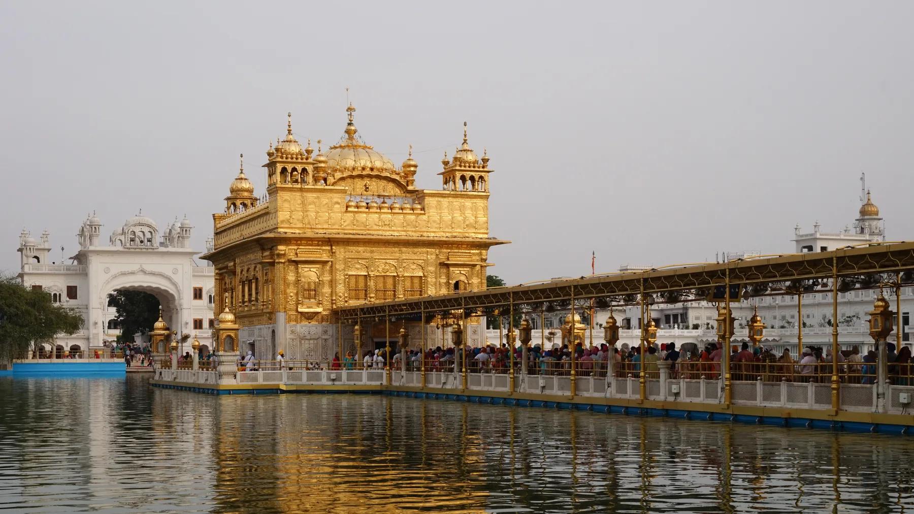 Golden Temple Harmandir Sahib reflected in the sarovar on a hazy day in Amritsar, reachable with self-drive car rental in Amritsar