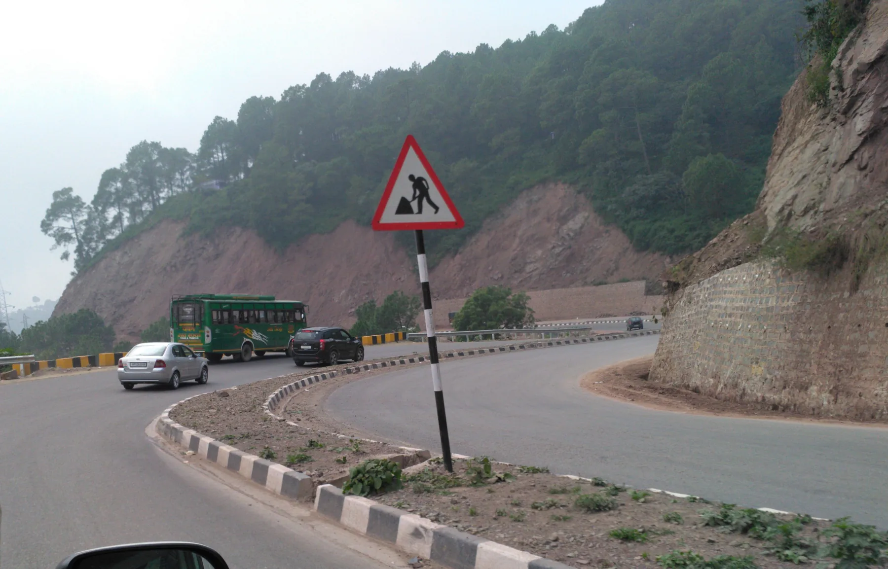 The Kalka to Shimla highway curving below a cut hillside and pine forest above Parwanoo, the road a Chandigarh rider takes to Dagshai