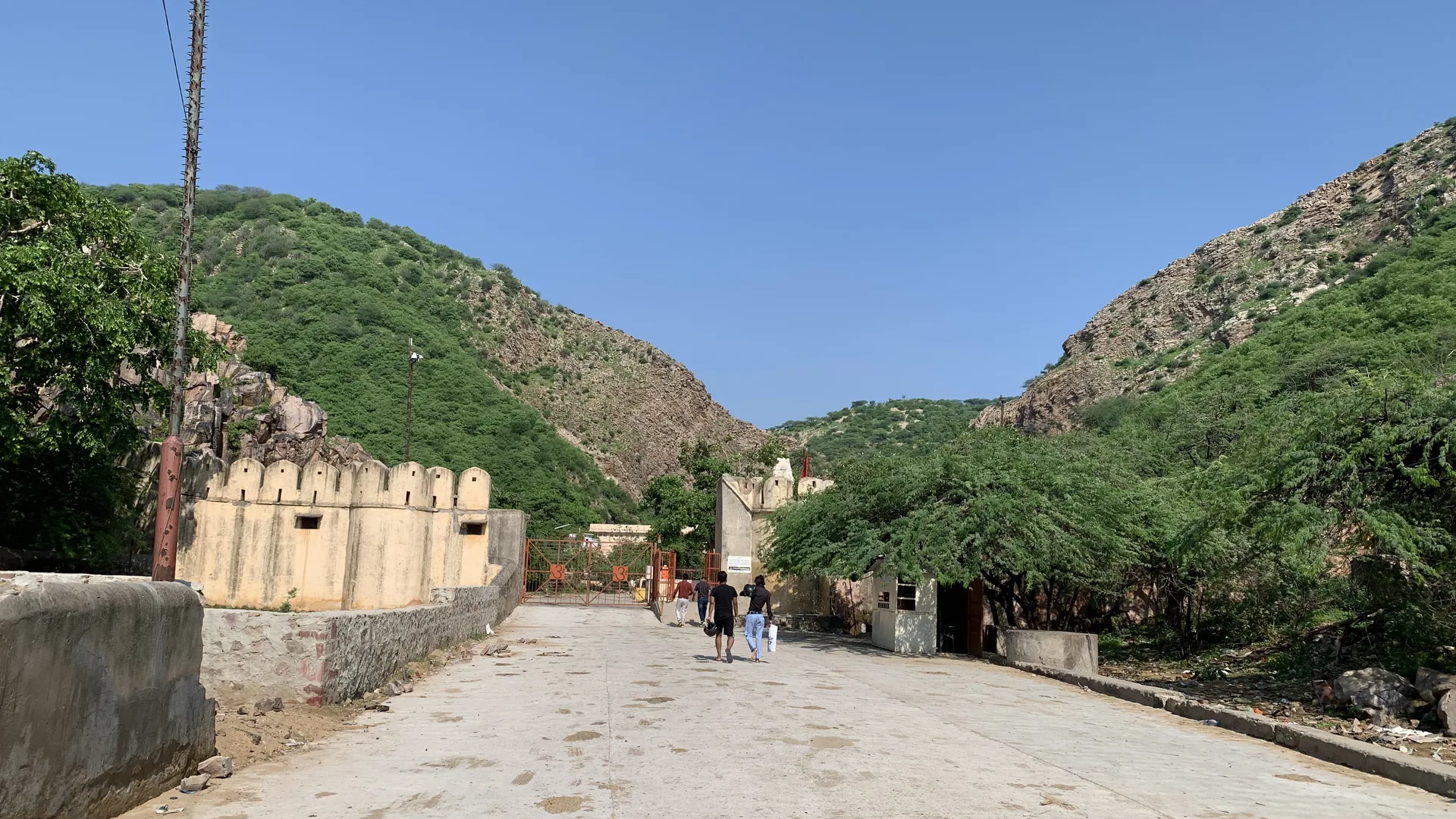 Pink sandstone temples and pavilions of Galta Ji nestled in an Aravalli gorge east of Jaipur, a morning stop on a bike rental in Jaipur