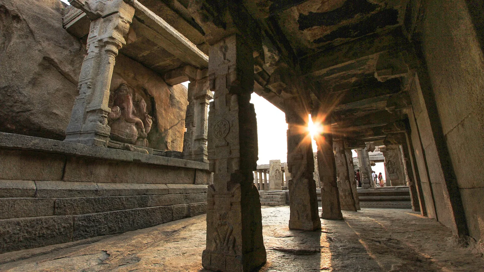 Pillared stone mandapa of Veerabhadra Temple at Lepakshi with sunlit granite columns, a stop on a self-drive car rental in Bangalore day trip
