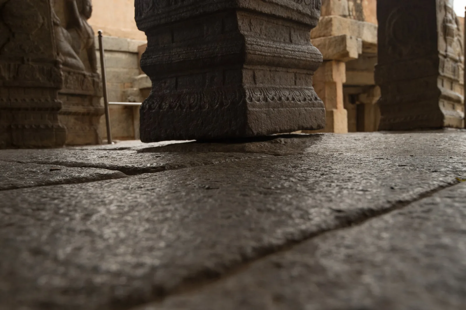 Base of the hanging pillar at Veerabhadra Temple Lepakshi showing the gap above the stone floor, reached by self-drive car rental in Bangalore