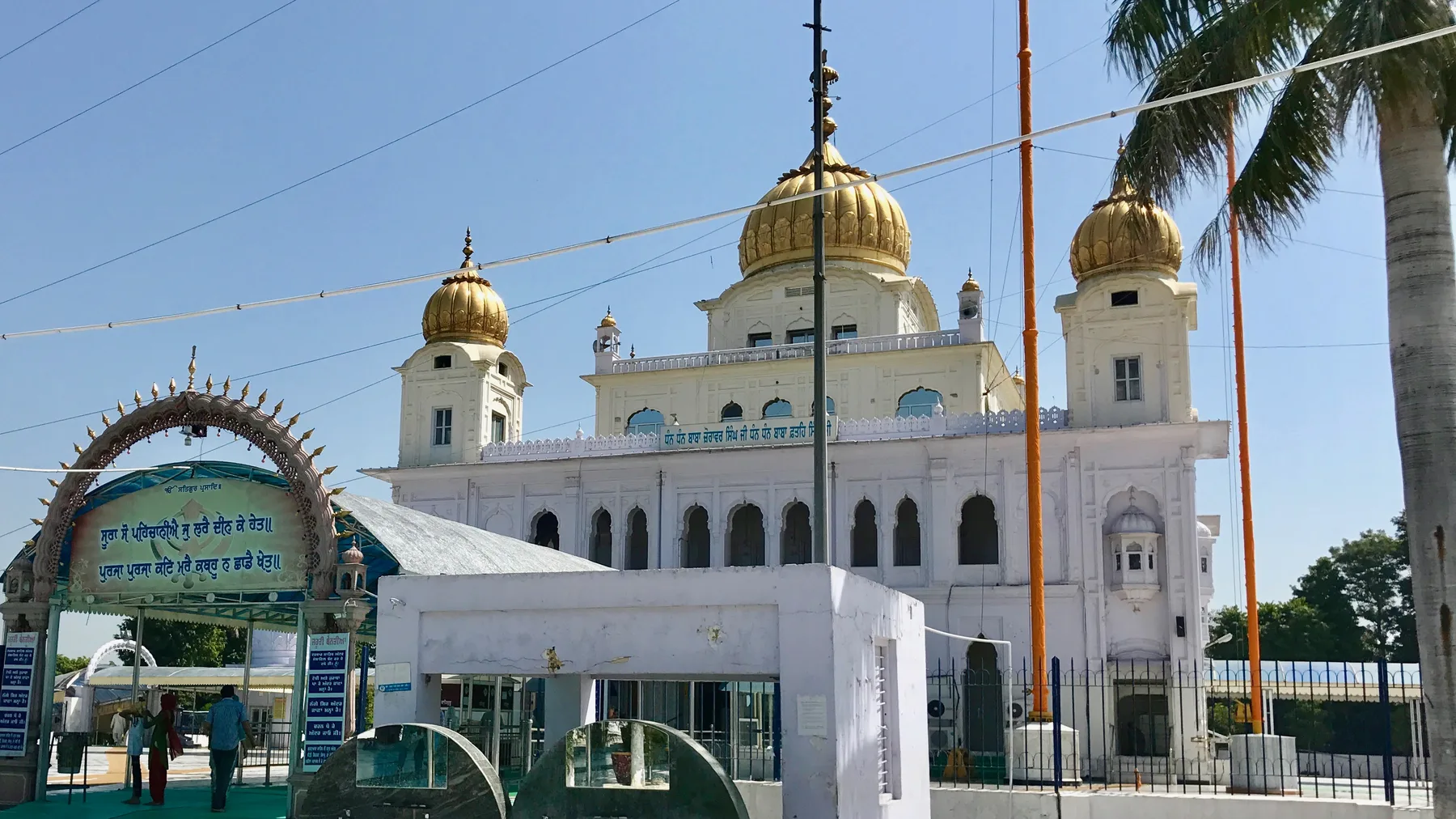 Gurdwara Fatehgarh Sahib with its white facade and golden domes under a clear blue sky, the main stop on a Sirhind day trip by self-drive car rental in Chandigarh