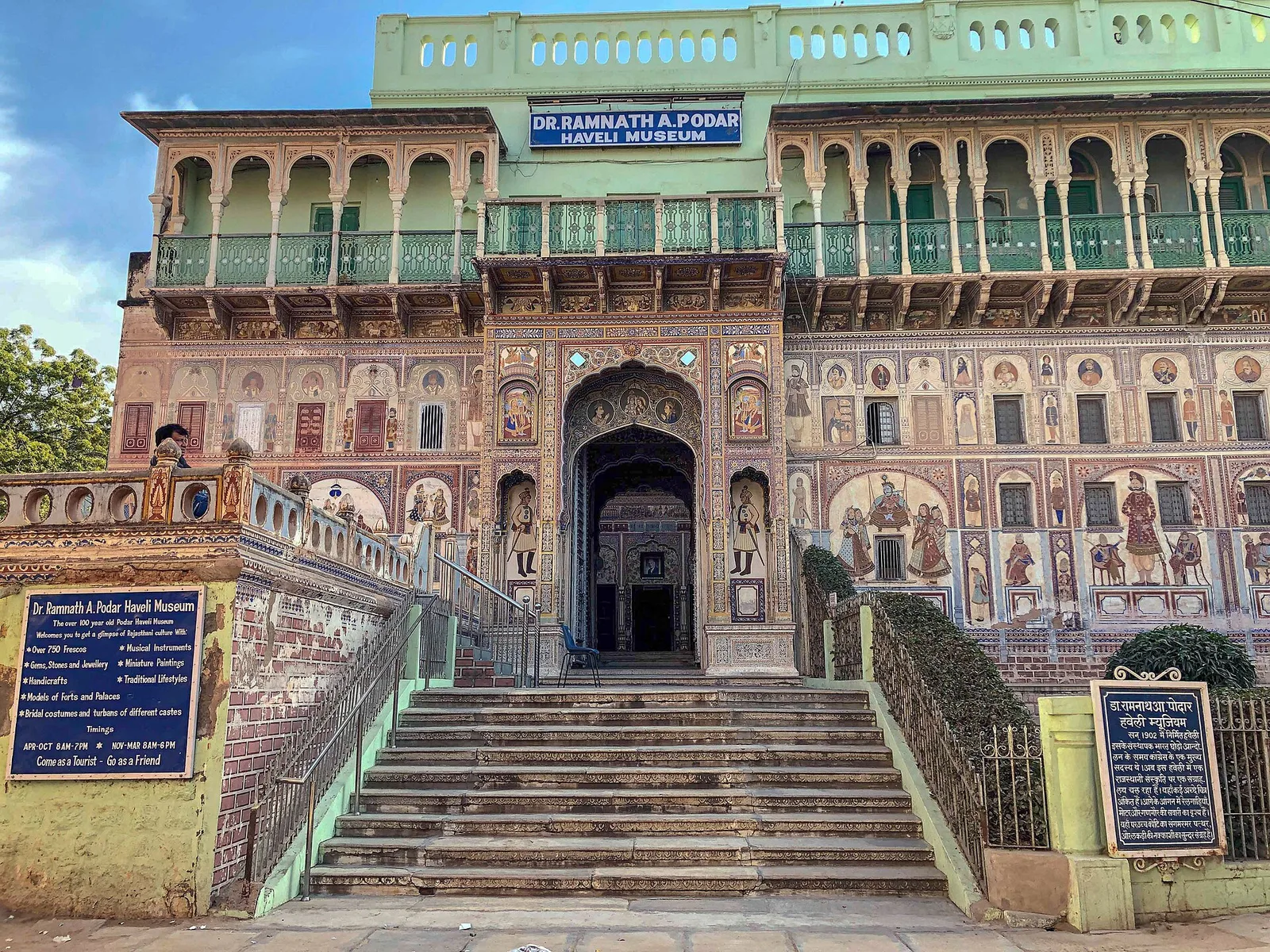 The Dr. Ramnath A. Podar Haveli Museum in Nawalgarh, a frescoed haveli with a green upper gallery, an arched entrance and a wide flight of steps
