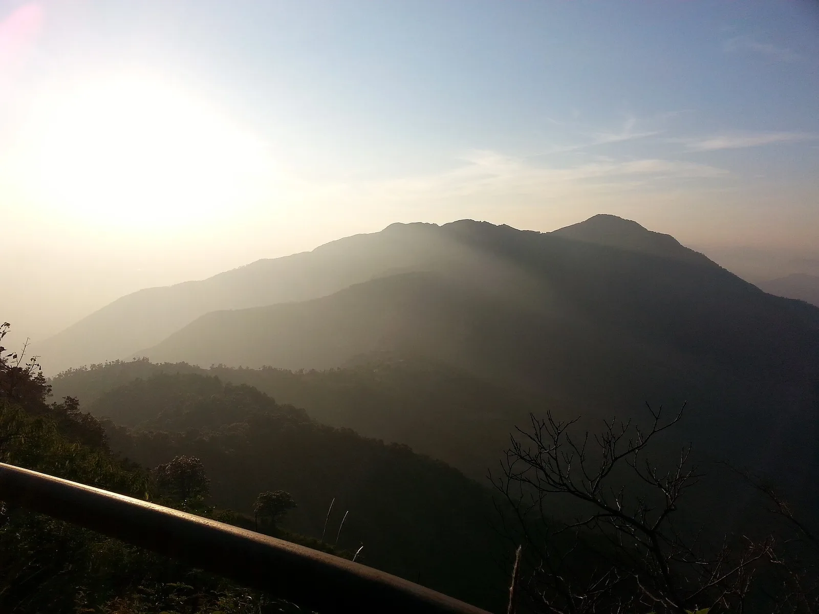 Sunset haze over forested ridges seen from a railing near Cloud End, at the western edge of Mussoorie