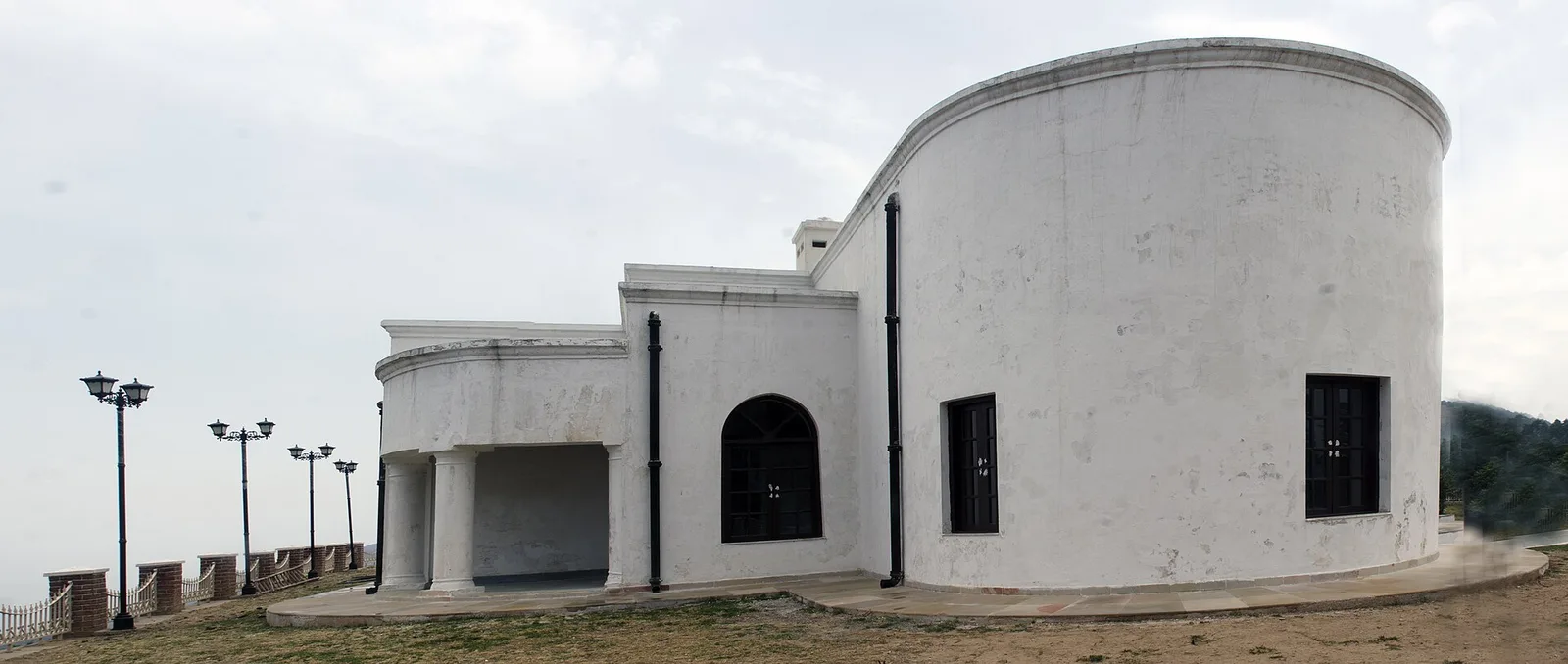 The white, curved walls of Sir George Everest's restored house at Park Estate, west of Mussoorie, with lamp posts along the ridge