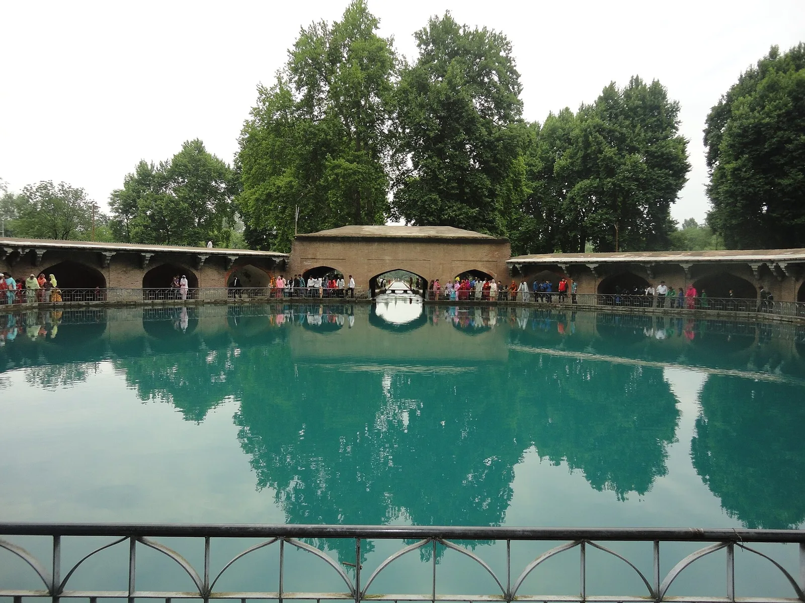 The turquoise octagonal spring pool at Verinag, ringed by a Mughal stone arcade and tall trees