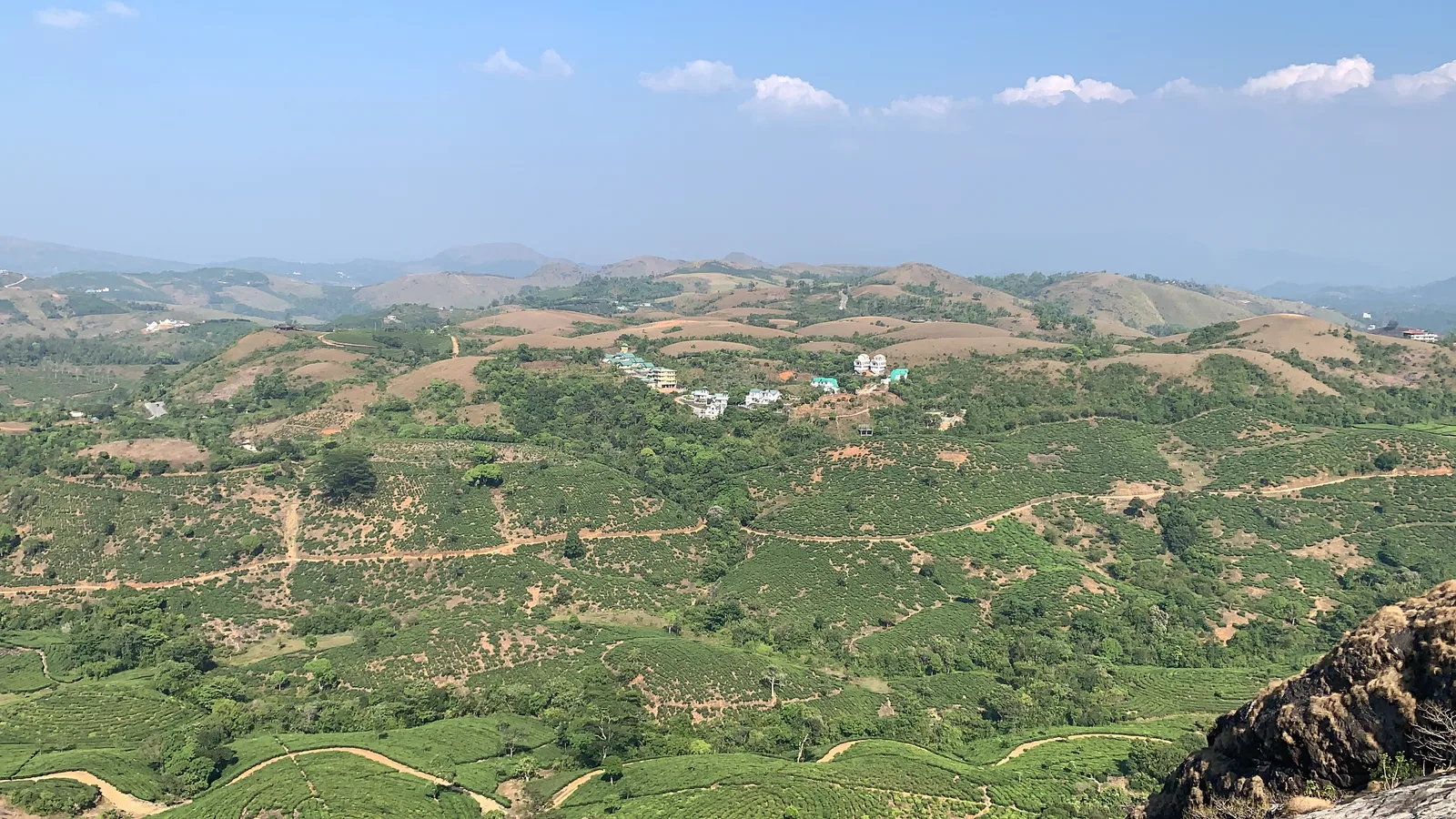 View from Thangal Para at Kolahalamedu over tea gardens, scattered houses and bare hills around Vagamon on a clear day