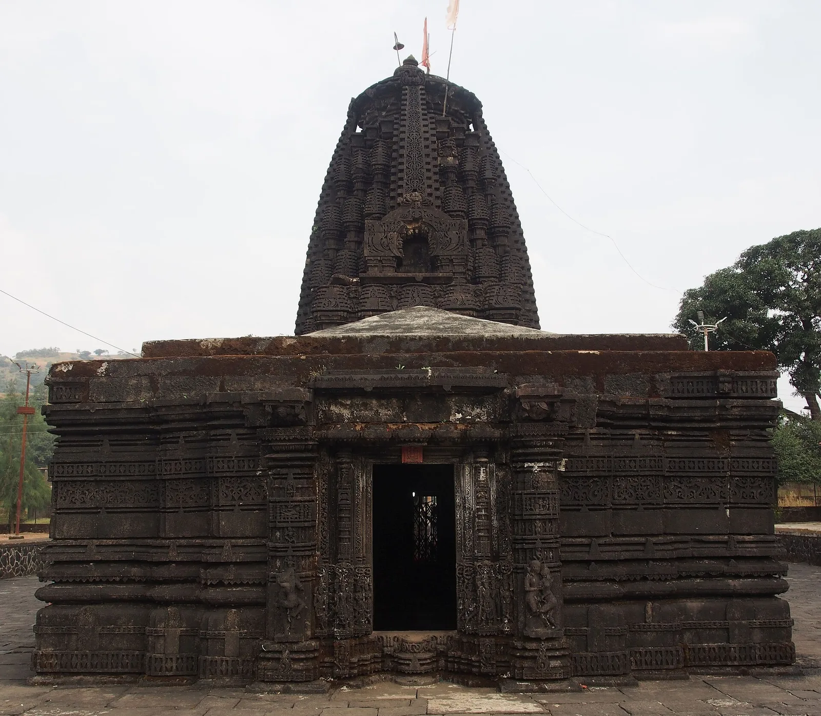 The black stone Amruteshwar temple at Ratanwadi near Bhandardara, with a carved curved spire over a low mandapa and a dark doorway