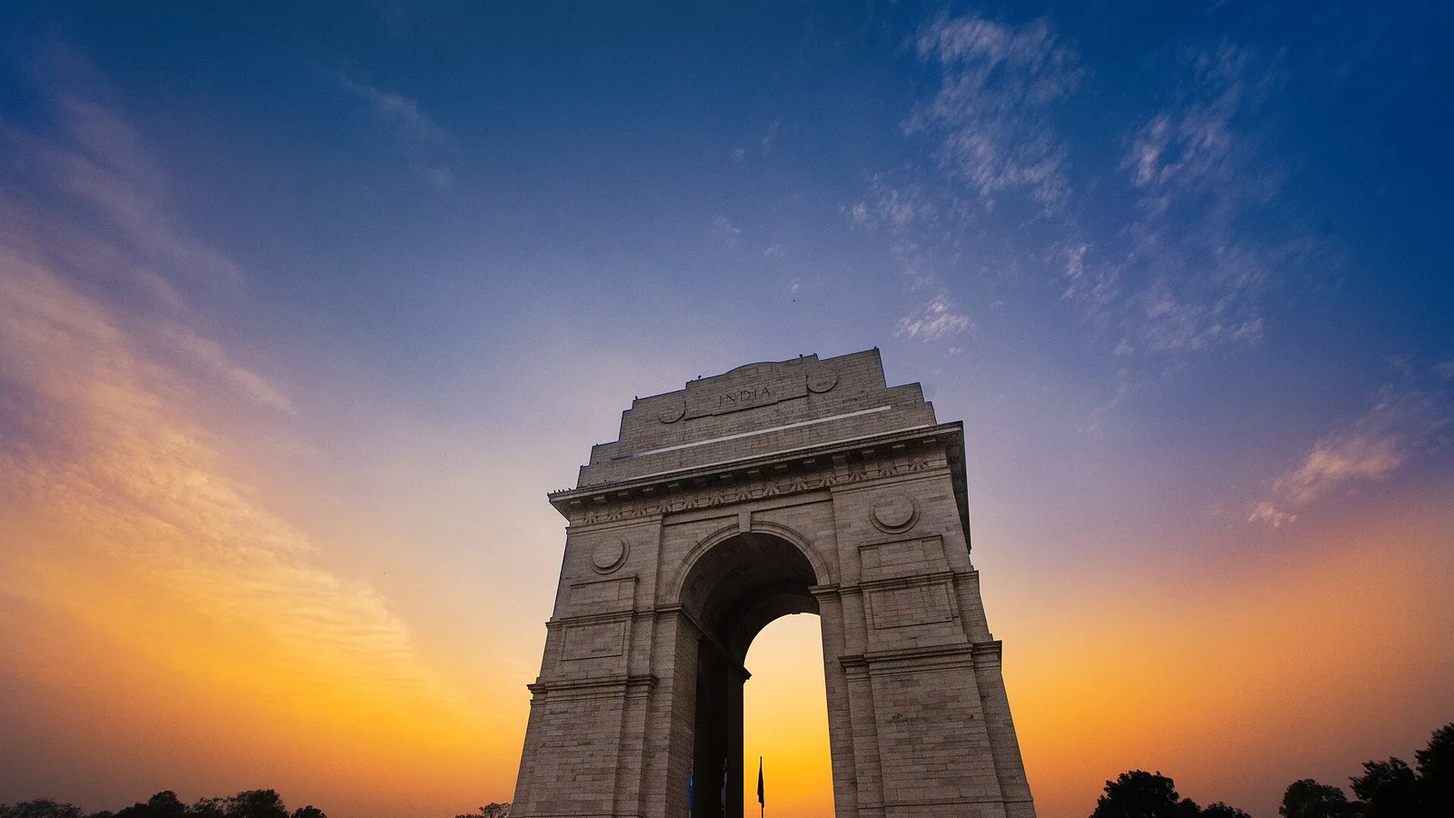 India Gate in New Delhi against an orange evening sky