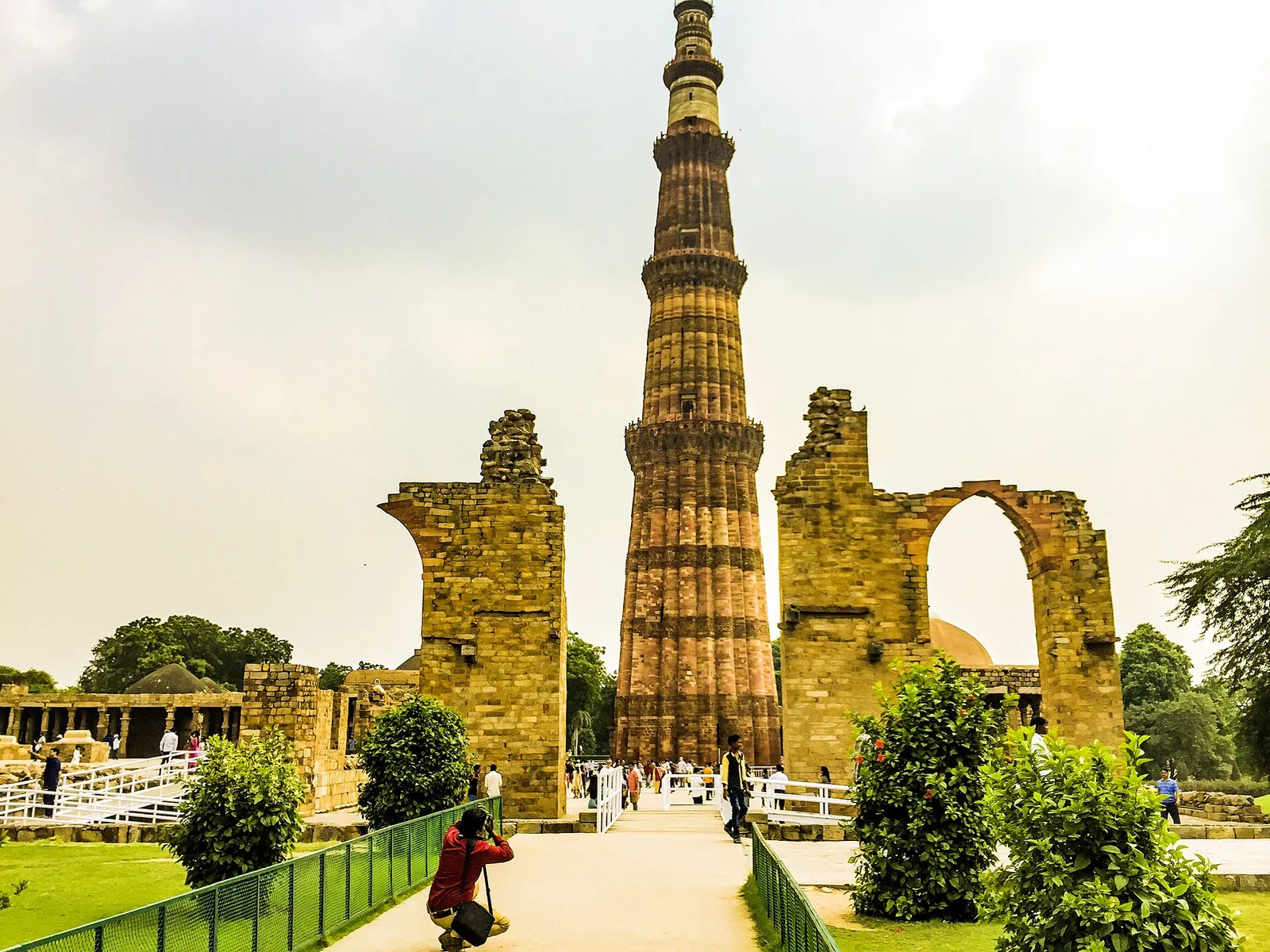 Qutub Minar rising above ruined arches in Delhi